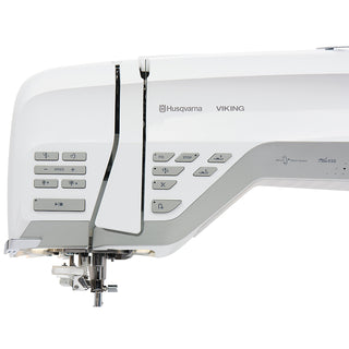 Close-up of a white Husqvarna Viking Designer Ruby 90 sewing and embroidery machine by 38-SVP - Singer Viking Pfaff, showing control buttons, brand logo, and needle area.