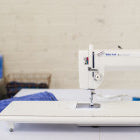 A Baby Lock Accomplish Quilting and Sewing Machine on a white table.