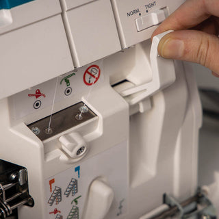 A person is using a PFAFF sewing machine (the Pfaff Admire Air 5000) to sew a button.