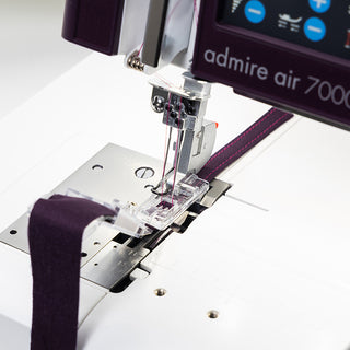 A Pfaff Admire Air 7000 sewing machine with a purple strap attached to it.