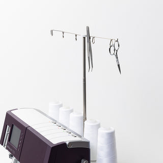 A Pfaff Admire Air 7000 sewing machine sits on a table with scissors and spools of thread.