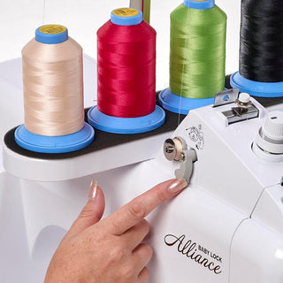 A person is using a Baby Lock Alliance Embroidery Machine with different colored spools.