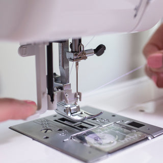 A person using a Baby Lock Zeal Sewing Machine to sew a piece of fabric.