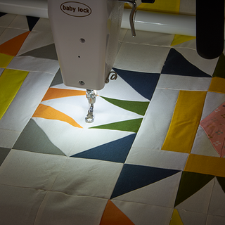 A quilt is being sewn on a Baby Lock Gallant with Villa Frame machine.