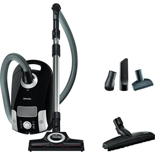 A black Miele Compact C1 Turbo Team Canister Vacuum with a hose and attachments.