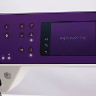 A purple and white Pfaff Expression 710 Sewing and Quilting Machine with buttons on it.