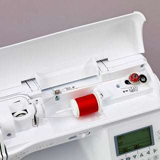 A Baby Lock Lyric Sewing & Quilting Machine with a red spool of thread.