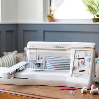 A Baby Lock Meridian Embroidery Only Machine sits on a wooden table.