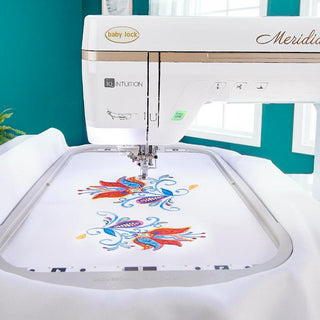 A white Baby Lock Meridian Embroidery Only Machine with a floral design on it.