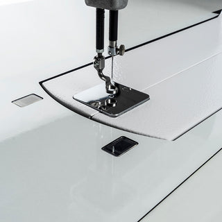 A Pfaff Powerquilter 1600 Stationary Quilter with Table on a white surface.
