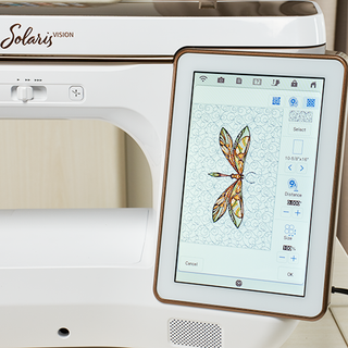 A Baby Lock Solaris Vision Sewing and Embroidery Machine with a tablet displaying a dragonfly design.
