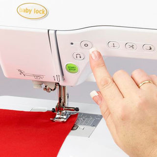 A person using a Baby Lock Soprano Sewing and Quilting Machine to sew a red fabric.