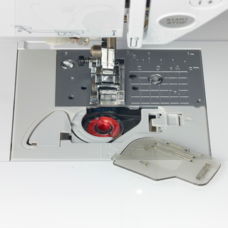 A Baby Lock Soprano Sewing and Quilting Machine with a red button on it.