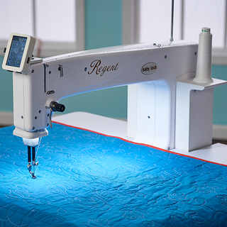 A Baby Lock Regent Longarm 18" Quilting Machine with a blue quilt on it.