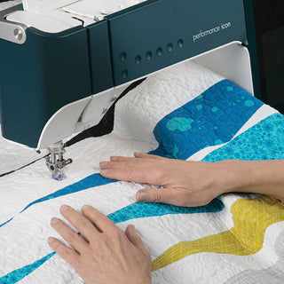 A person is using a PFAFF Performance Icon Sewing and Quilting Machine to make a quilt.