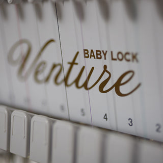 A Baby Lock Venture with Table embroidery machine with the word Baby Lock written on it.