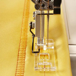 A Husqvarna Viking sewing machine on a yellow fabric.