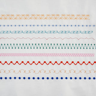 A white piece of fabric with different colored threads on it, made using the Baby Lock Altair Sewing & Embroidery Machine.