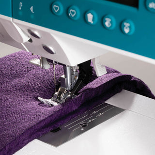 A Pfaff Ambition 620 Sewing and Quilting Machine with a purple fabric on it.