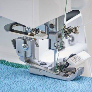 A Baby Lock Celebrate Serger is being used to sew a piece of fabric.