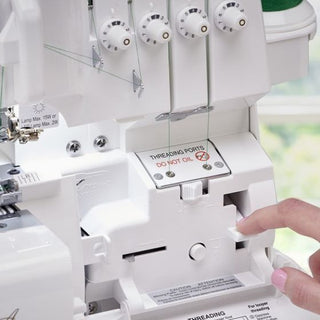 A person is using a Baby Lock Celebrate Serger sewing machine to sew a piece of fabric.