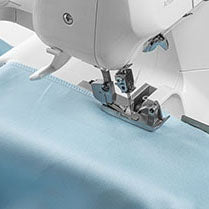 A Husqvarna Viking sewing machine with a blue fabric on it.