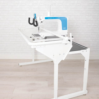A white and blue PFAFF Powerquilter 1650 Stand Up Quilter with 5' Frame on a white table.