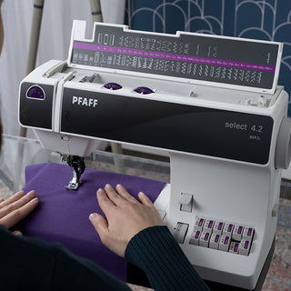 A woman is sewing on a PFAFF Select 4.2 sewing machine.
