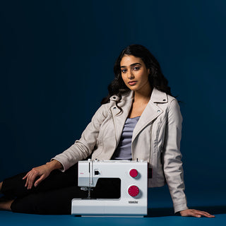 A woman posing with a Smarter by Pfaff 160s sewing machine.